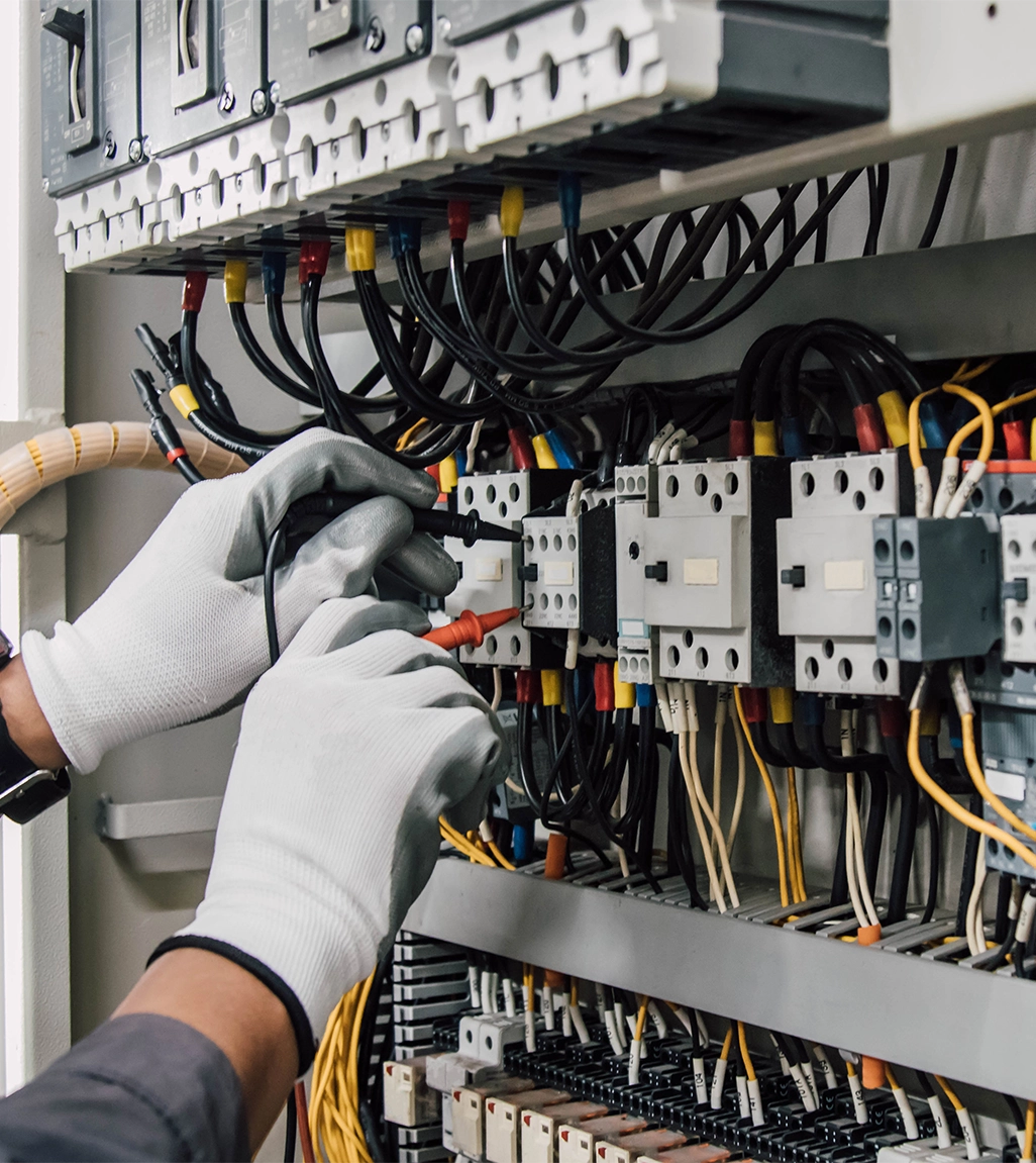 Ein Elektriker testet elektrische Anlagen und Leitungen an einem Relaisschutzsystem.